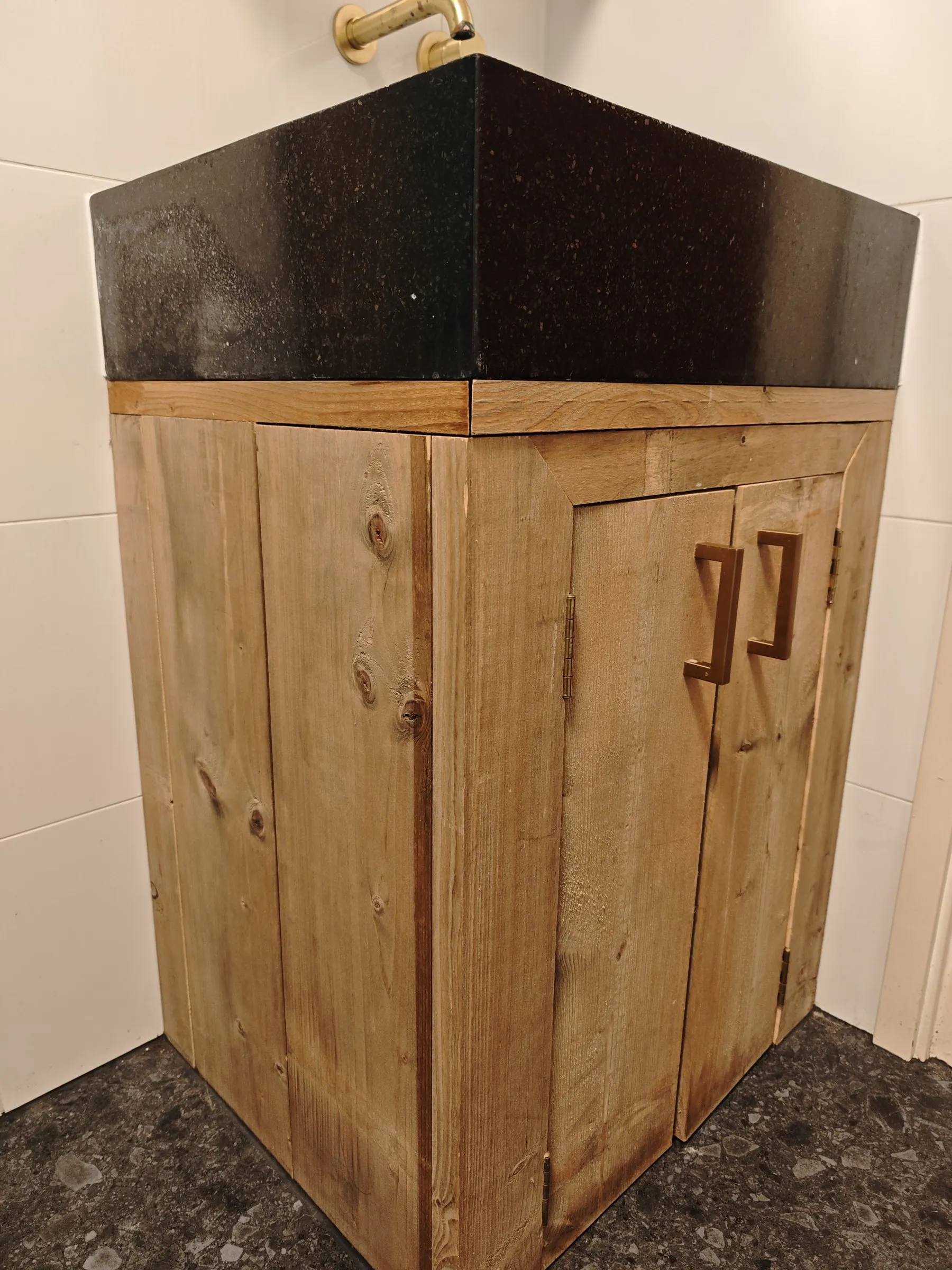 Het houten wastafelmeubel met zwarte waskom van dichtbij