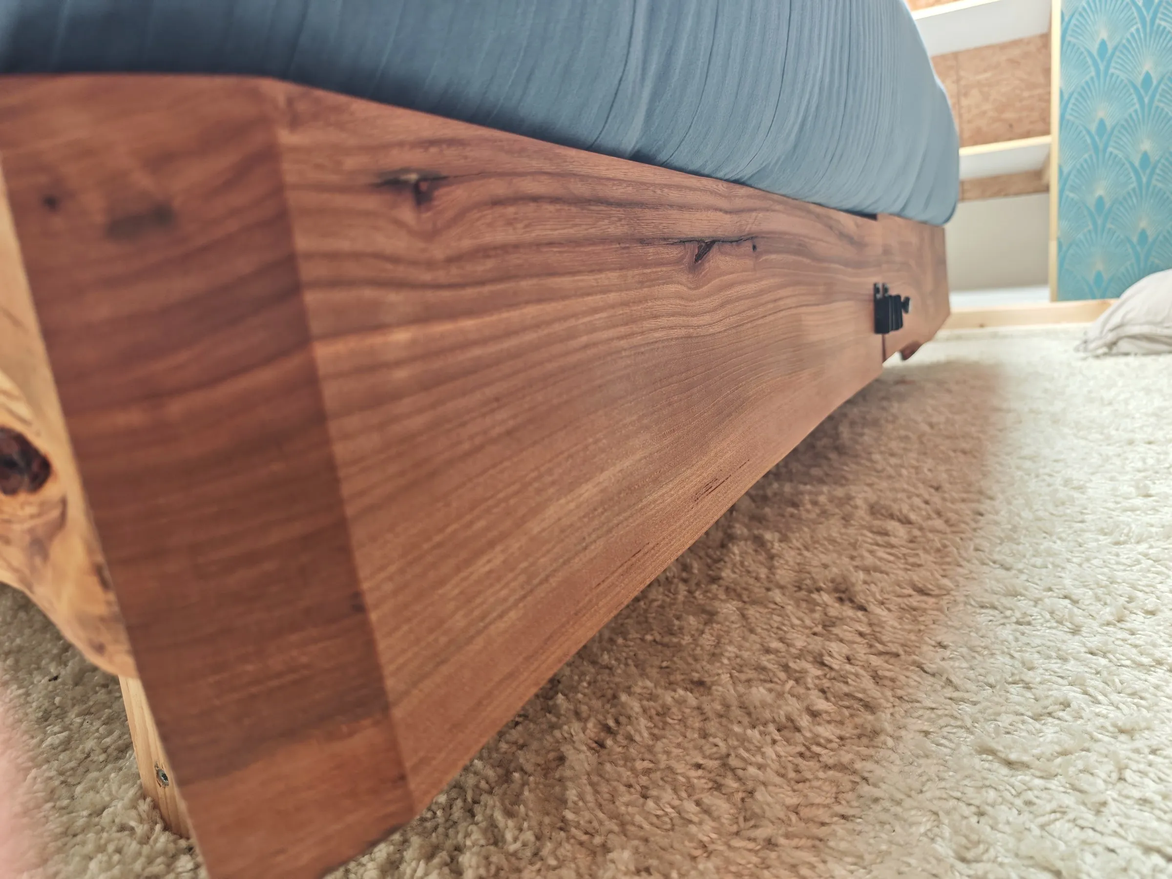 Zijkant van het bedframe, laag langs het tapijt gefotografeerd