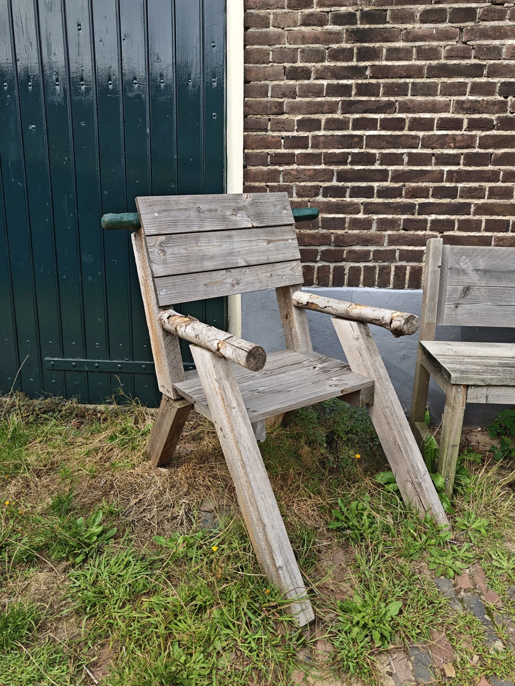 Tuinstoel voor een groene schuurdeur